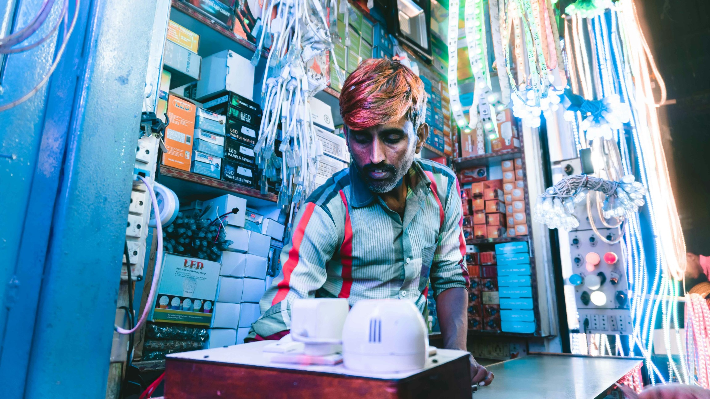 Salesperson in electronics stall, India